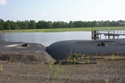 Active coal ash pond with geotextile tubes installed around perimeter
